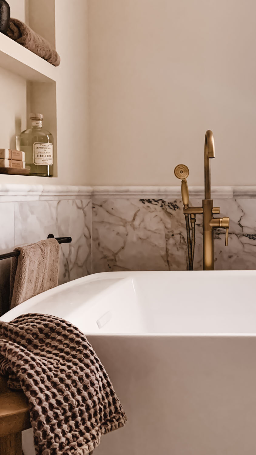 Oversized soaking tub in custom primary bathroom renovation with aged brass fixtures Oversized soaking tub in custom primary bathroom renovation with aged brass fixtures