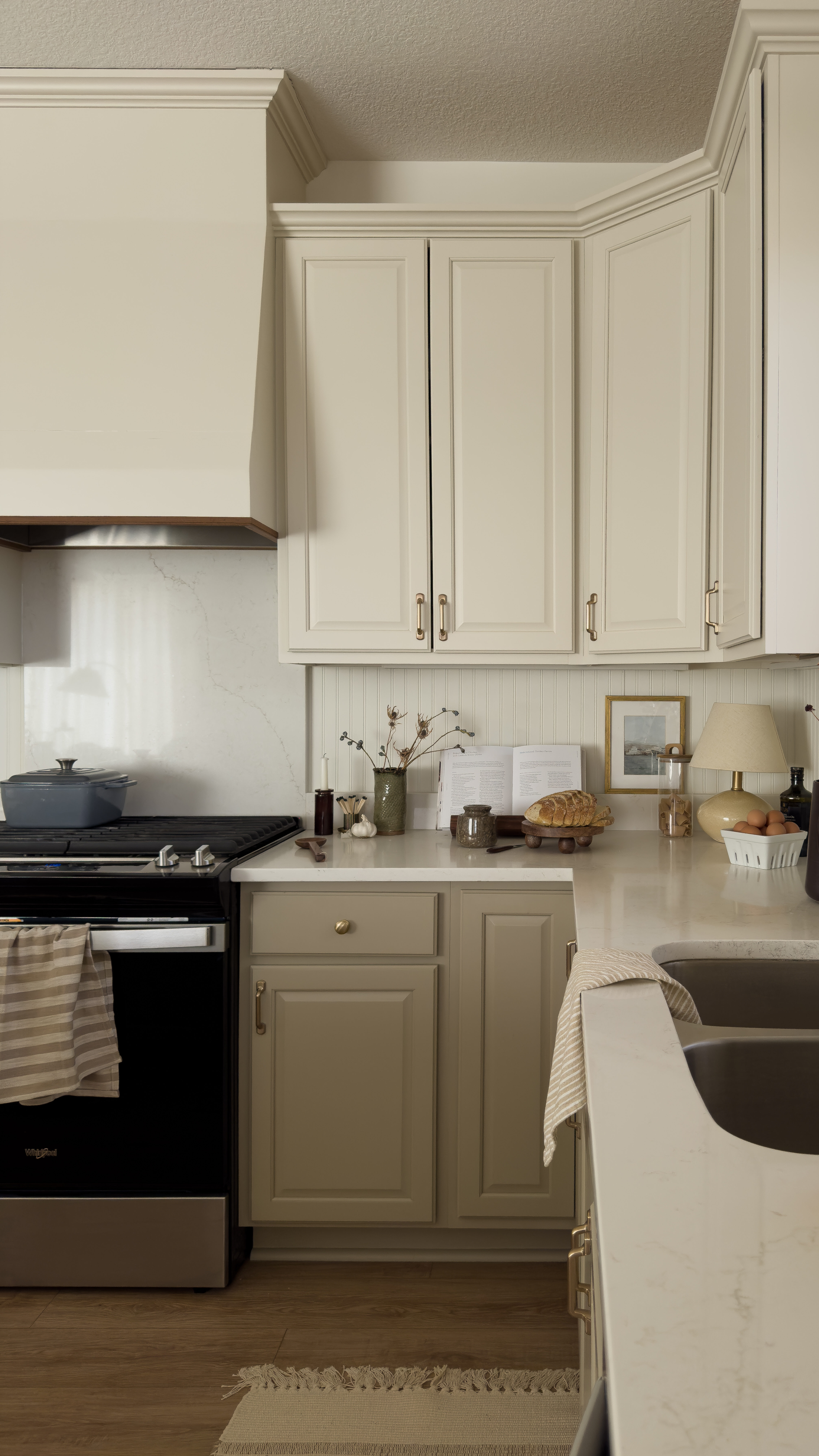 Warm custom kitchen design with walnut trim hood and slab quartz backsplash Warm custom kitchen design with walnut trim hood and slab quartz backsplash